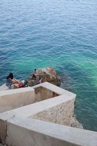 High angle view of people sitting by sea