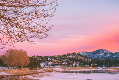 Scenic view of snow covered field against sky at sunset