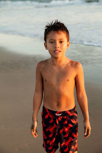 Portrait of shirtless boy standing at beach