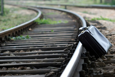 Close-up of suitcase on railroad track