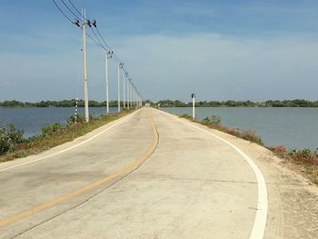 Road by river against sky