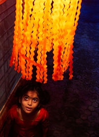 High angle view of girl looking at illuminated lantern