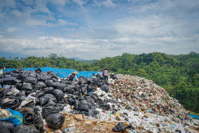 People are selecting trash in a garbage landfill in malang regency