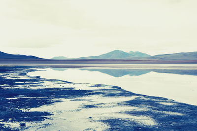 View of calm lake against mountain range