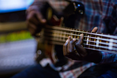 Midsection of man playing guitar