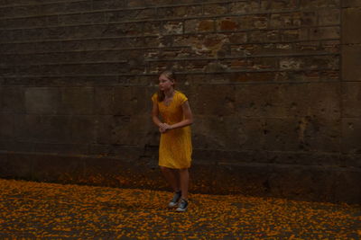 Portrait of a woman standing against brick wall