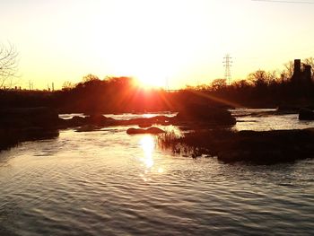 Scenic view of river against clear sky during sunset