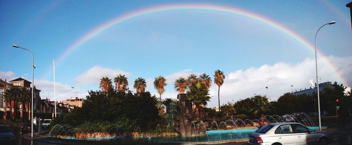 Panoramic view of rainbow over city against sky