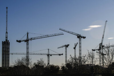 Cranes at construction site against sky