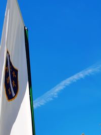 Low angle view of flag against blue sky