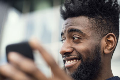 Low angle view of happy man using mobile phone