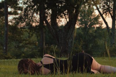 Woman laying in a  field as the summer sun goes down