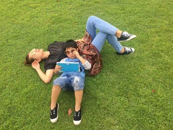 High angle view of mother and son lying on grassy field