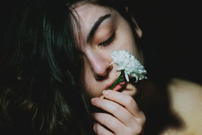 Close-up portrait of a beautiful woman with red eyes closed