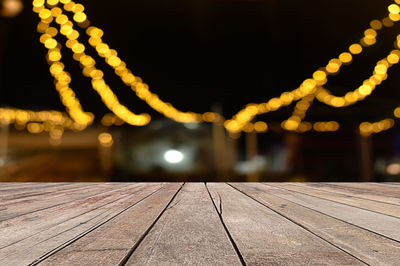 Close-up of illuminated lights on footpath at night