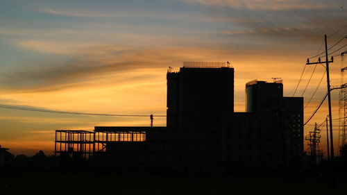 Silhouette buildings against sky during sunset