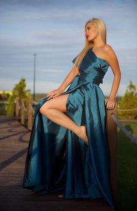 Portrait of young woman standing against sky