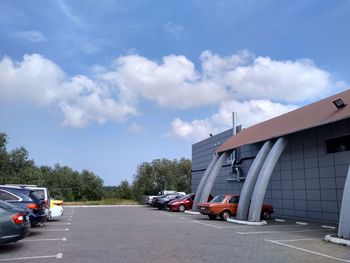 Cars on road in city against sky