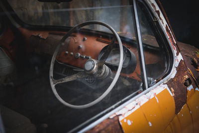 Steering wheel in damaged car seen through window