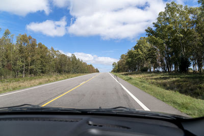 Road amidst trees against sky