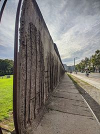 Footpath in park against sky