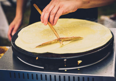 Close-up of person preparing food on stove