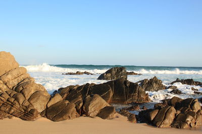 Panoramic view of rocks on beach against sky