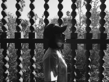 Woman standing against gate