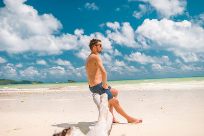 Full length of shirtless man at beach