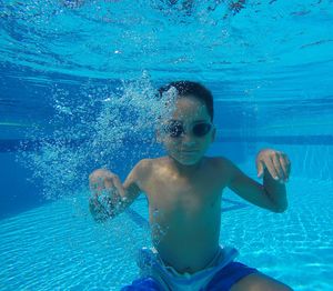 Portrait of shirtless boy swimming in pool