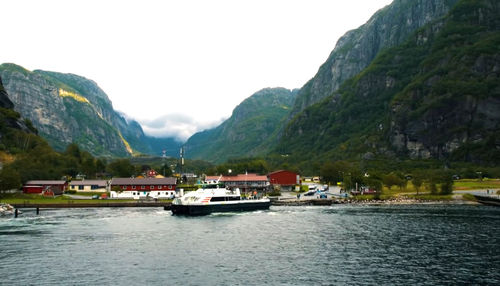 Scenic view of sea and mountains against clear sky