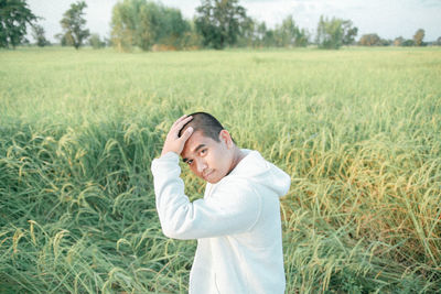 Portrait of young woman standing on field