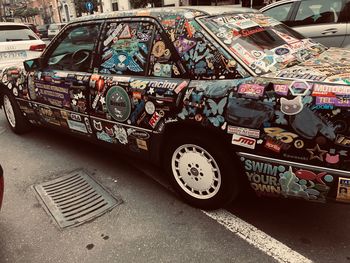 Graffiti on abandoned car on road