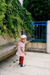 Full length of boy standing against trees