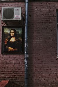 Portrait of young woman against brick wall