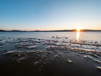 Scenic view of sea against clear sky during sunset