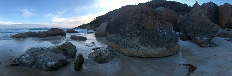 Rocks on beach against sky