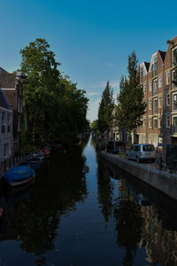 Canal amidst buildings in city against sky