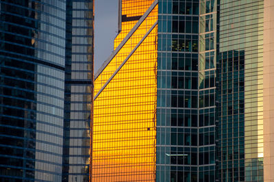 Moscow city glass skyscrapers at sunset, close up view of various buildings