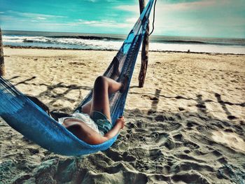 Woman relaxing in hammock at beach