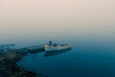 Boat moored on sea against sky