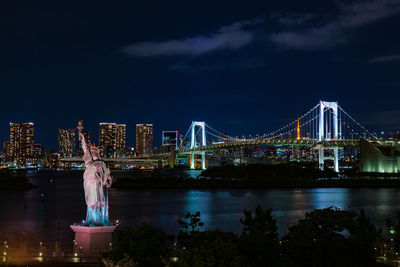 Illuminated golden gate bridge over river against sky at night