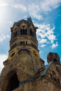 Low angle view of church tower against cloudy sky