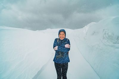 Portrait of young woman standing in snow