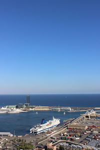 High angle view of boats moored in sea against clear blue sky