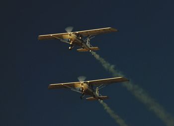 Low angle view of airplane flying against clear blue sky