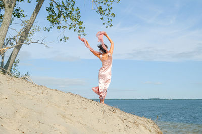 Full length of woman on beach against sky