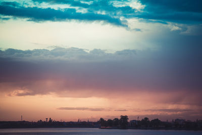 Scenic view of dramatic sky over city during sunset