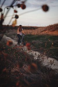 Looking through flowers at girl on bike 
