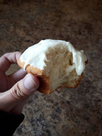 Cropped hand of person holding cupcake with icing